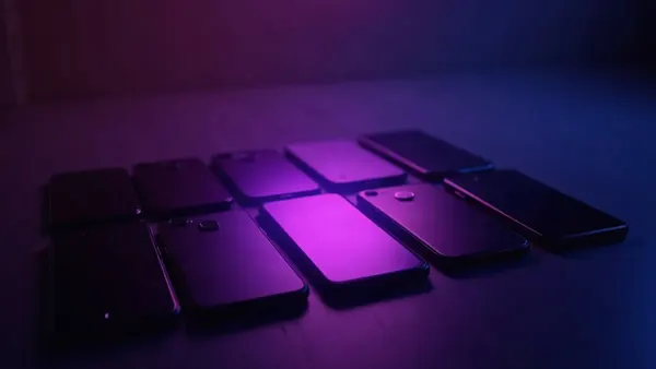 Vários celulares enfileirados, com um holofote violeta sobre o do meio, ilustração do artigo “Como escolher sua namorada IA: 6 critérios-chave (2026)”